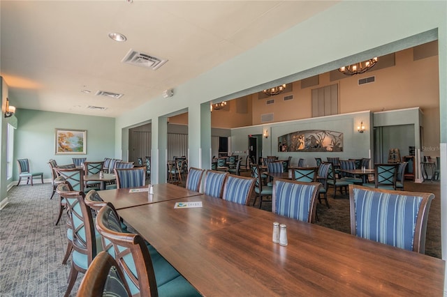 carpeted dining area featuring a chandelier