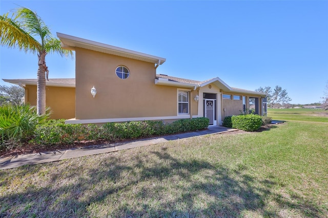 view of front facade featuring a front yard and stucco siding