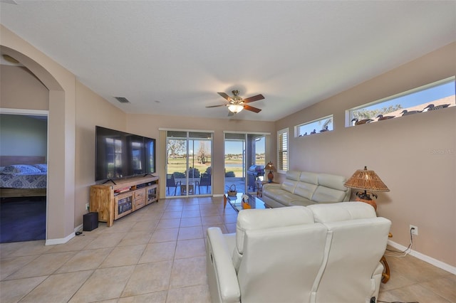 living area with visible vents, ceiling fan, baseboards, and light tile patterned flooring