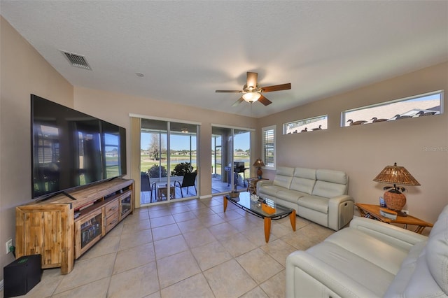 living room with visible vents, ceiling fan, a textured ceiling, and light tile patterned flooring
