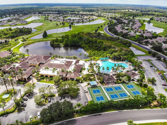 drone / aerial view featuring a residential view, view of golf course, and a water view