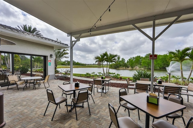 view of patio with outdoor dining area and a water view
