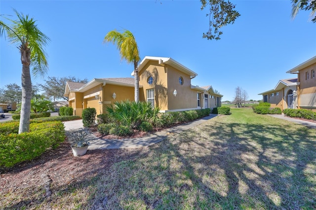 view of side of home featuring a lawn and stucco siding