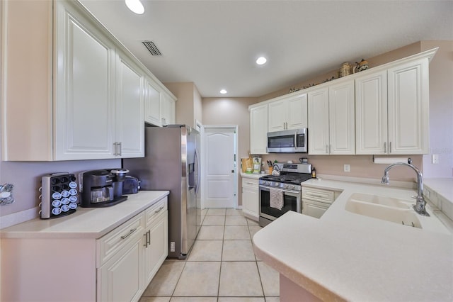 kitchen featuring appliances with stainless steel finishes, white cabinets, and a sink