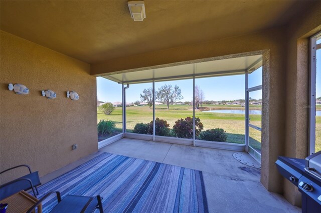 unfurnished sunroom with a healthy amount of sunlight and a water view