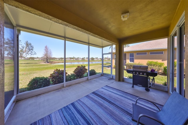 sunroom / solarium featuring a water view