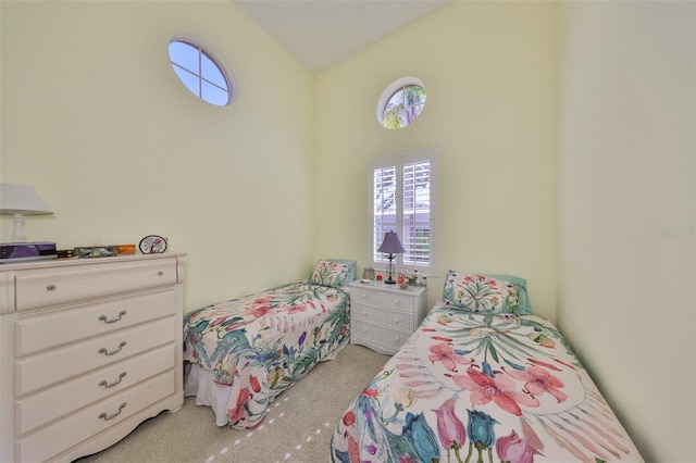 bedroom with vaulted ceiling and light colored carpet
