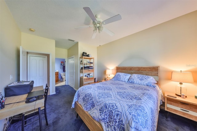 bedroom with ceiling fan, visible vents, baseboards, dark colored carpet, and ensuite bath