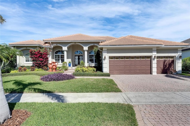 mediterranean / spanish house with a garage and a front yard