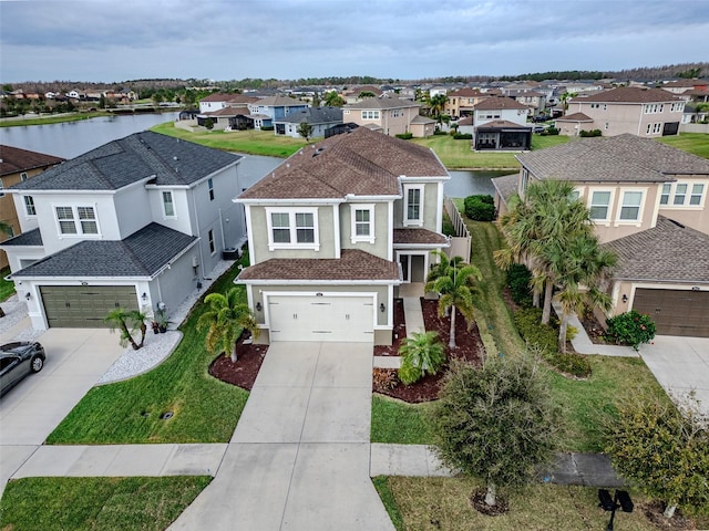 drone / aerial view featuring a water view and a residential view