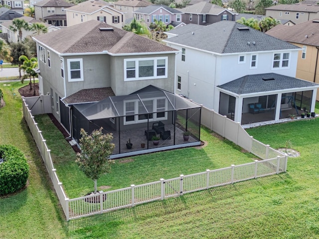 back of property featuring a lanai, a fenced backyard, a residential view, and a shingled roof