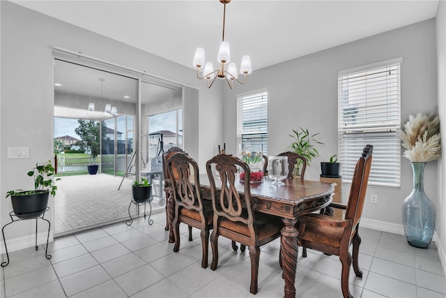 dining room featuring a notable chandelier, baseboards, and light tile patterned floors