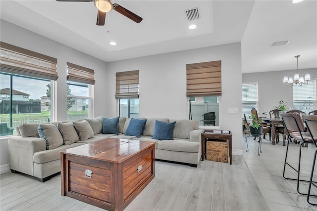 living room featuring recessed lighting, visible vents, light wood-style flooring, and ceiling fan with notable chandelier