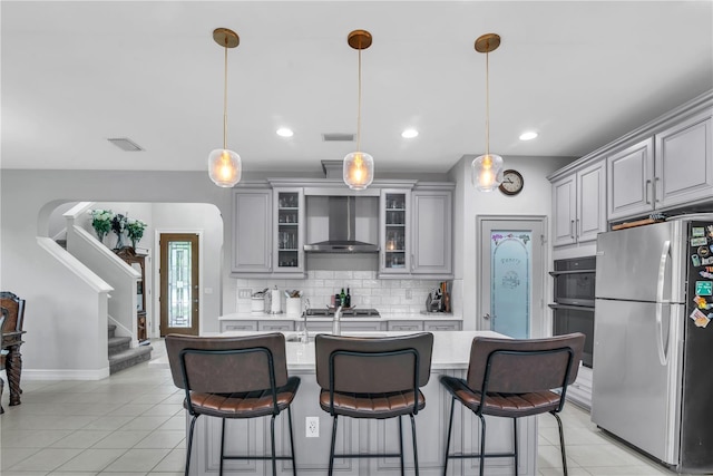 kitchen featuring gray cabinets, glass insert cabinets, stainless steel appliances, and light countertops