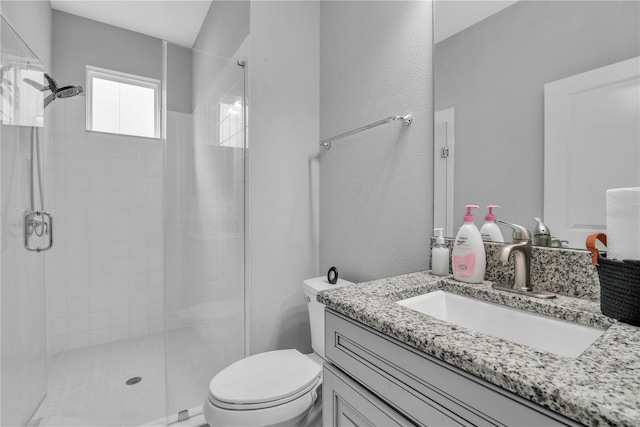 bathroom with toilet, a shower stall, and vanity