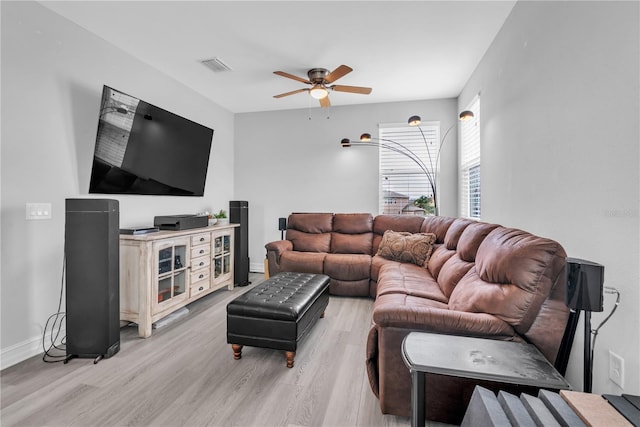 living room featuring ceiling fan, light wood finished floors, visible vents, and baseboards