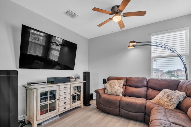 living room featuring a healthy amount of sunlight, light wood-style floors, ceiling fan, and visible vents