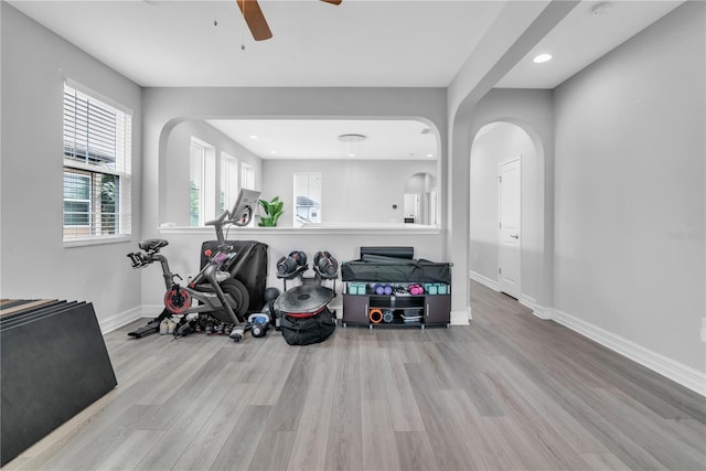 workout area featuring light wood-style floors, baseboards, a ceiling fan, and recessed lighting