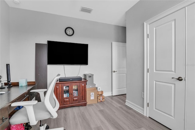 office with light wood finished floors, visible vents, and baseboards