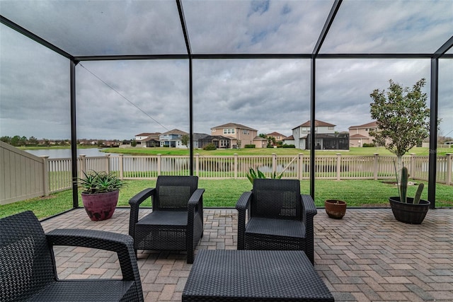 view of patio featuring a fenced backyard, a water view, a lanai, and a residential view