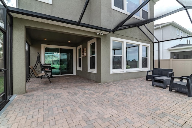 view of patio featuring a lanai, fence, and outdoor lounge area