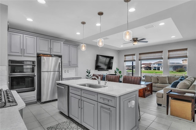 29011 Trevi Pl, Wesley Chapel, FL 33543 - kitchen with stainless steel appliances, gray cabinetry, light countertops, open floor plan, and ceiling fan