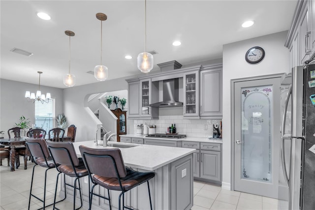 29011 Trevi Pl, Wesley Chapel, FL 33543 - kitchen featuring appliances with stainless steel finishes, gray cabinets, wall chimney range hood, light countertops, and light tile patterned floors