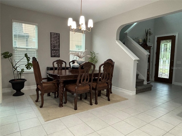 29011 Trevi Pl, Wesley Chapel, FL 33543 - dining room featuring light tile patterned floors, a chandelier, and stairs