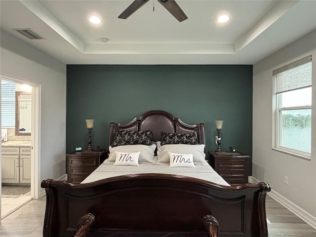 29011 Trevi Pl, Wesley Chapel, FL 33543 - bedroom featuring a raised ceiling, ensuite bathroom, recessed lighting, a ceiling fan, and light wood-style floors