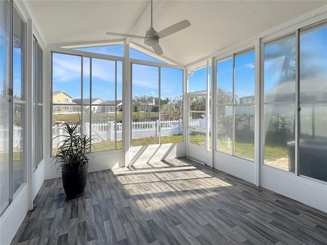 unfurnished sunroom with a water view, ceiling fan, a residential view, and lofted ceiling with beams