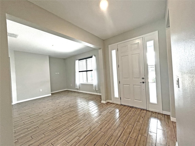 foyer with visible vents, light wood-style flooring, and baseboards