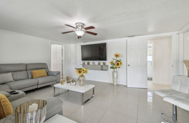 tiled living room featuring ceiling fan and a textured ceiling