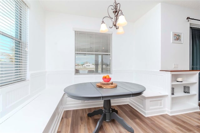 dining area with light hardwood / wood-style floors, an inviting chandelier, and breakfast area
