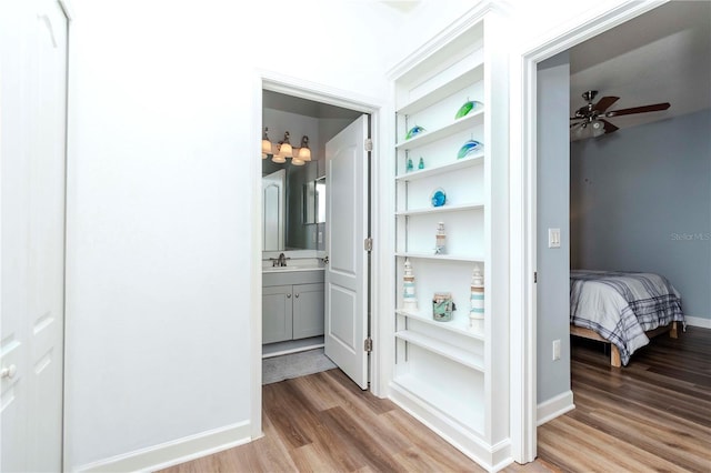 hall featuring light hardwood / wood-style flooring and built in shelves