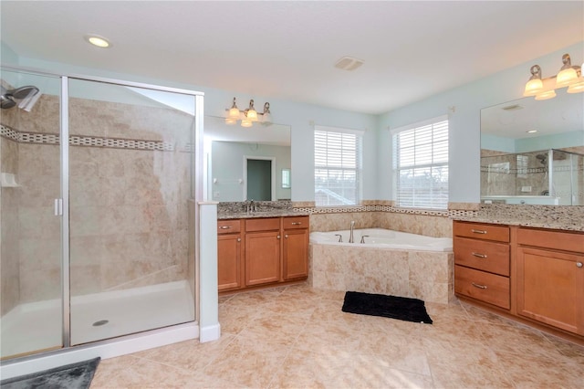 bathroom featuring plus walk in shower, vanity, and tile patterned flooring
