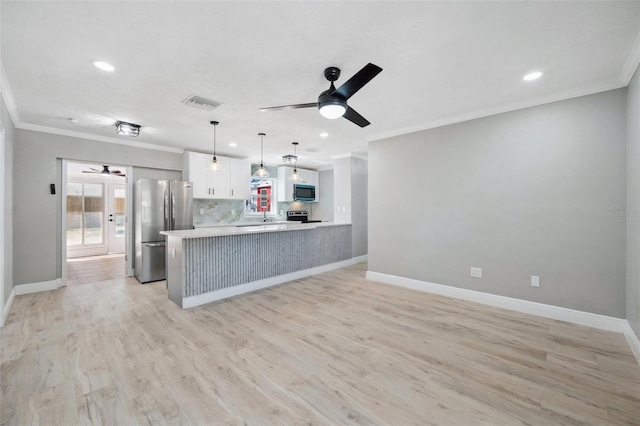 kitchen with baseboards, appliances with stainless steel finishes, light wood-type flooring, and crown molding