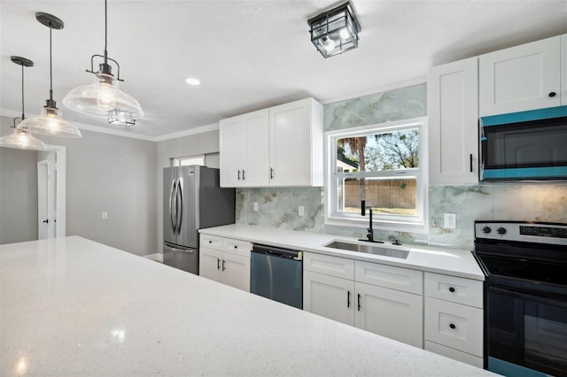 kitchen with hanging light fixtures, a sink, stainless steel appliances, white cabinetry, and backsplash