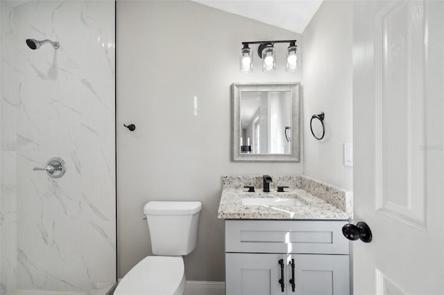 bathroom with toilet, a marble finish shower, and vanity