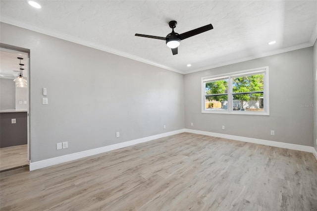 spare room with crown molding, a ceiling fan, a textured ceiling, wood finished floors, and baseboards