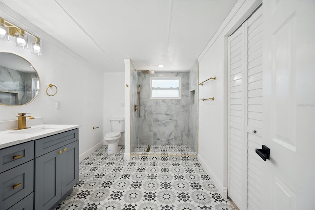 bathroom with a marble finish shower, baseboards, toilet, ornamental molding, and vanity