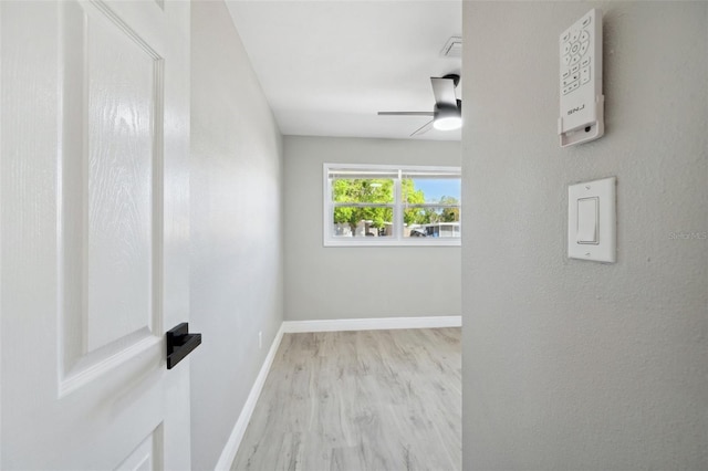 unfurnished room featuring ceiling fan, baseboards, and wood finished floors