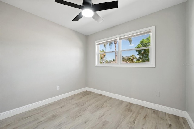 spare room featuring a ceiling fan, light wood-type flooring, and baseboards