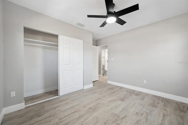 unfurnished bedroom with baseboards, a closet, visible vents, and wood finished floors