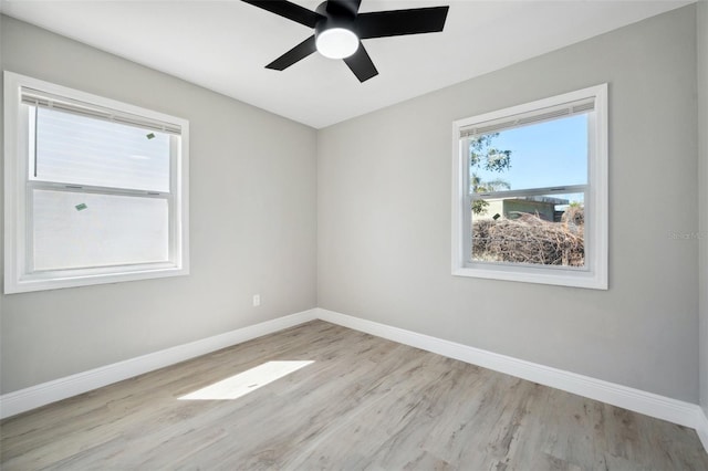 empty room with a ceiling fan, baseboards, and wood finished floors