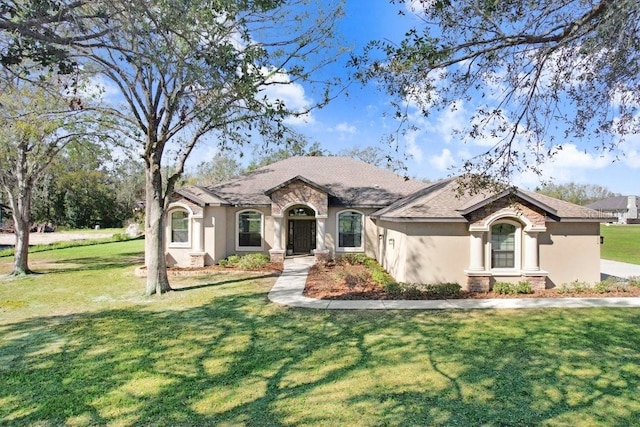 view of front of house with a front yard and stucco siding