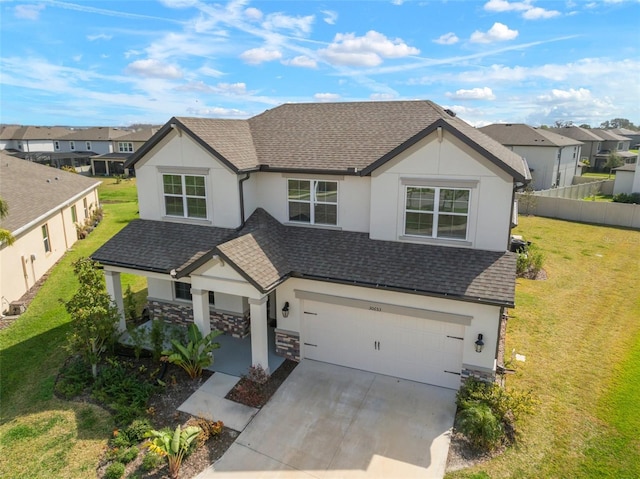 view of front of property featuring a residential view, concrete driveway, roof with shingles, and a front lawn