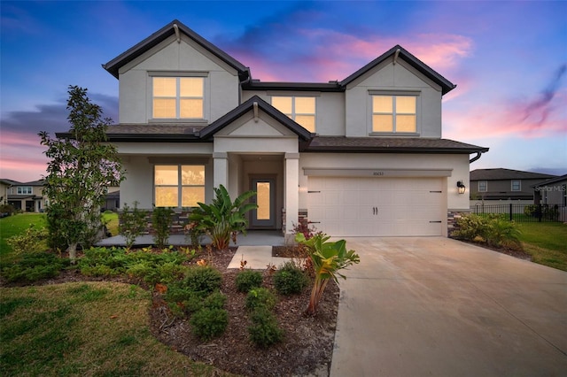 view of front of property with a garage, fence, concrete driveway, stucco siding, and a front yard