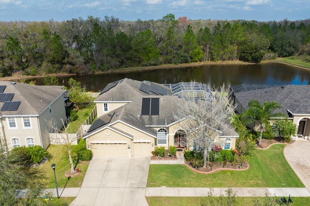 view of front facade with a garage, a water view, a front yard, and solar panels