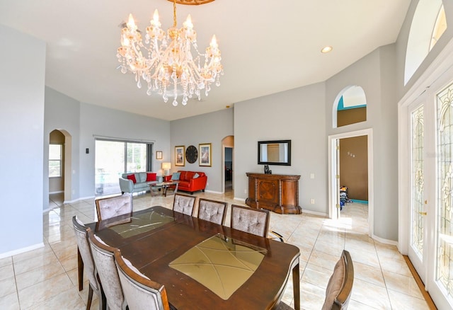 dining room featuring light tile patterned floors, a towering ceiling, and a chandelier