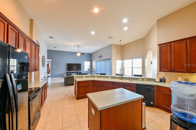 kitchen featuring a center island, light tile patterned floors, hanging light fixtures, and black appliances